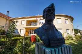 Škola v Končenici a busta místního válečného hrdiny Josefa Růžičky, který danou školu navštěvoval (2022)