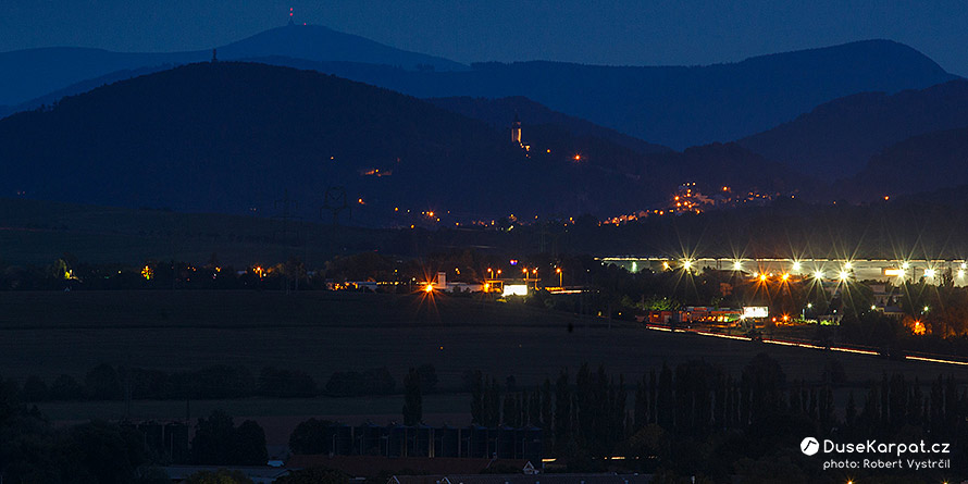 Noční pohled na Štramberskou Trúbu a beskydskou Lysou horu v pozadí