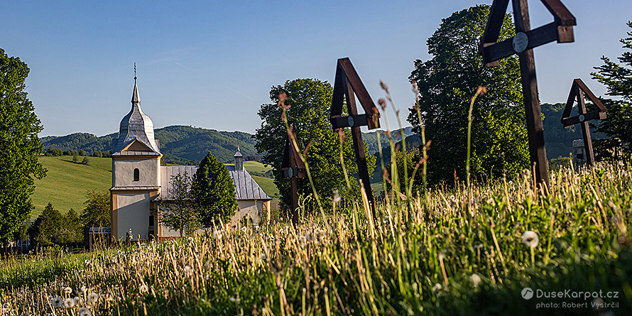 Řeckokatolický kostelík v Hostovicích pohledem mezi kříži hřbitova z 1. světové války