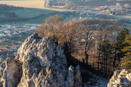 Vykukující bílá špička kostela sv. Mikuláše pohledem z Kršlenice (2023)