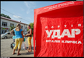 Skole (Сколе) - stánek politické strany Udar (česky Úder) a žena oblečená v ukrajinských barvách